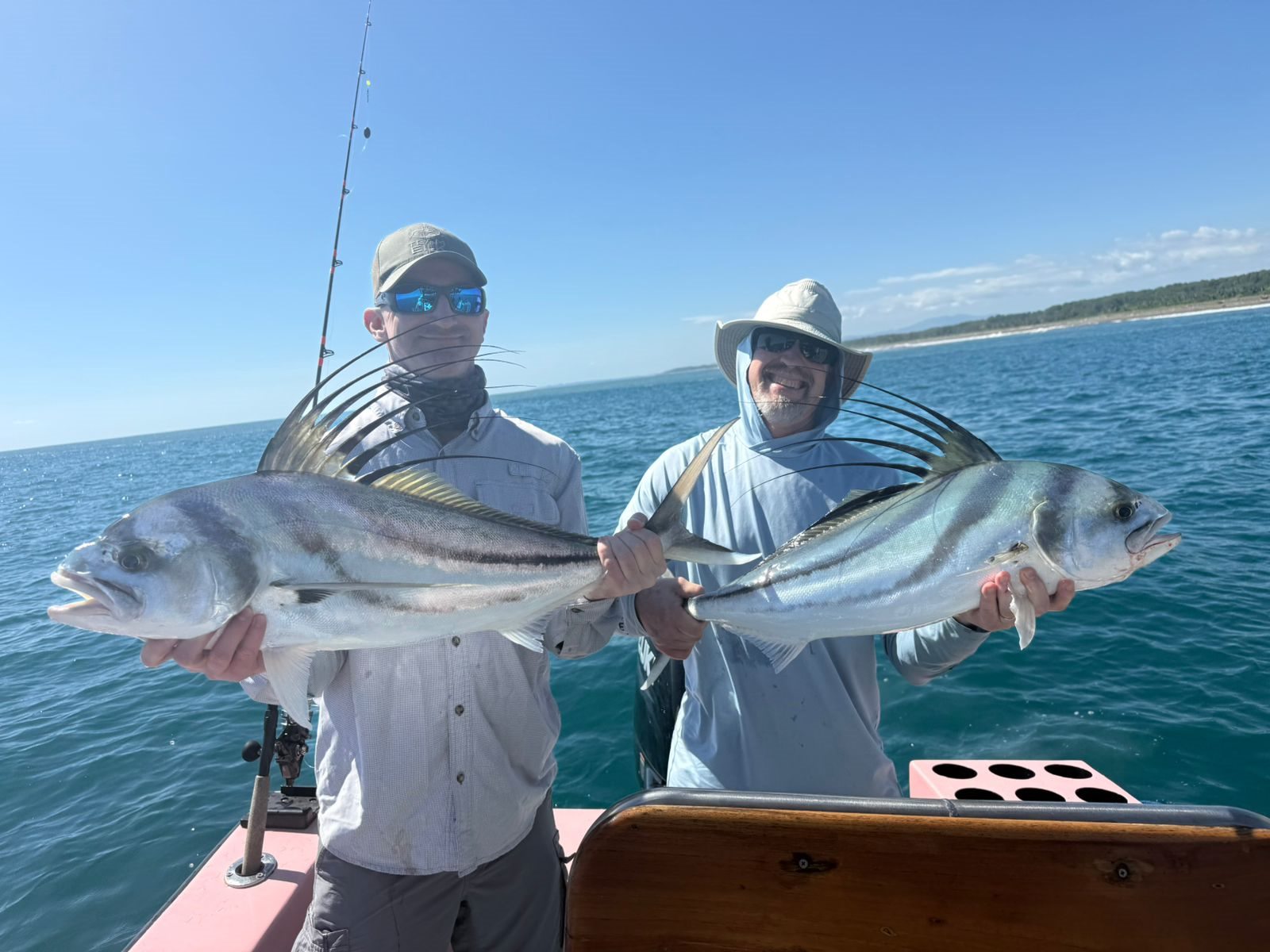 Two anglers displaying two fish together
