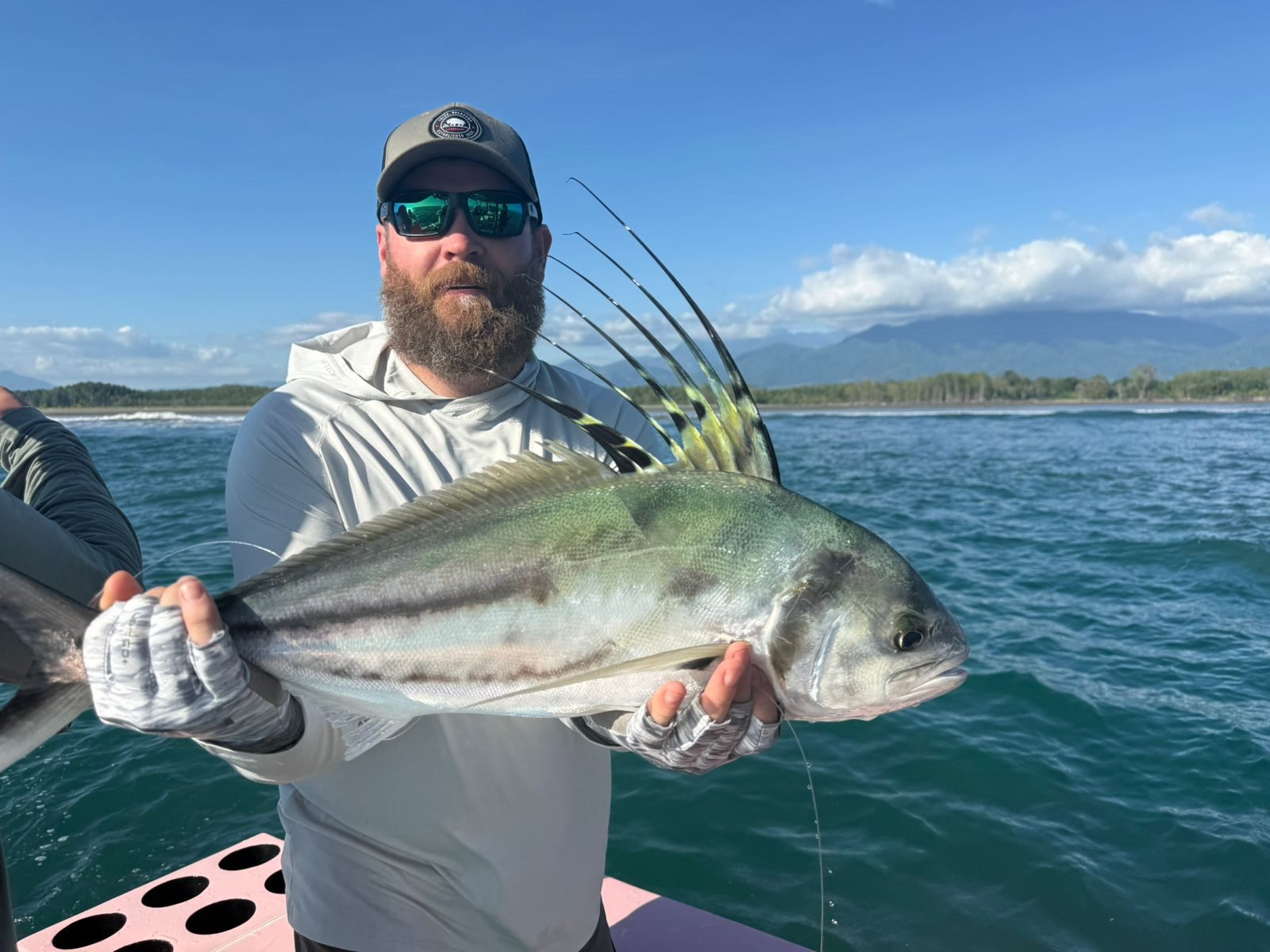 Angler holding a large roosterfish close to the camera