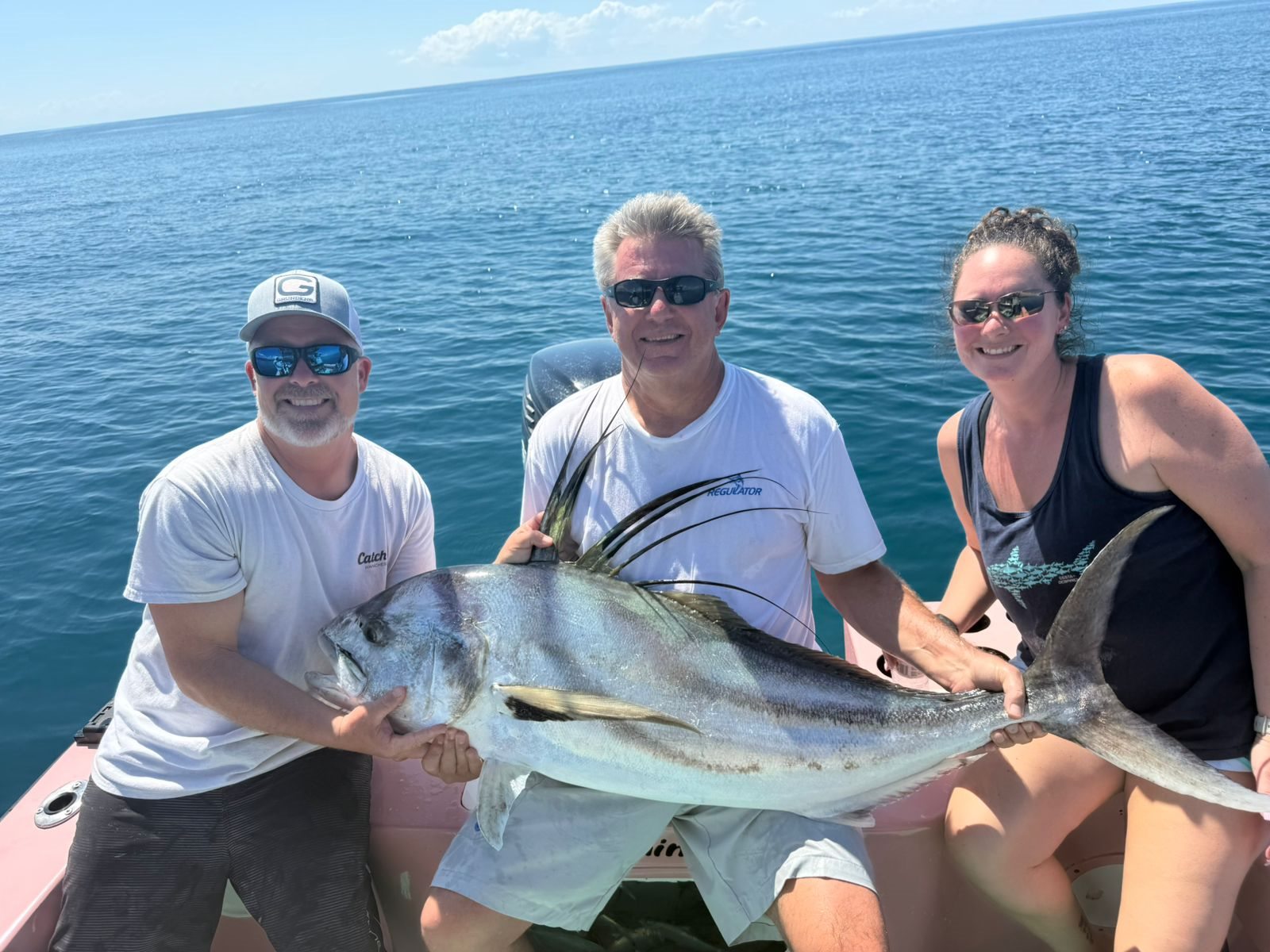 Group of friends smiling with a large roosterfish