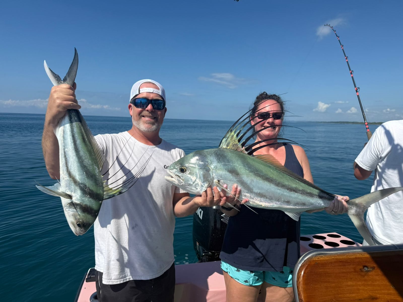 Happy adult anglers showing several fish