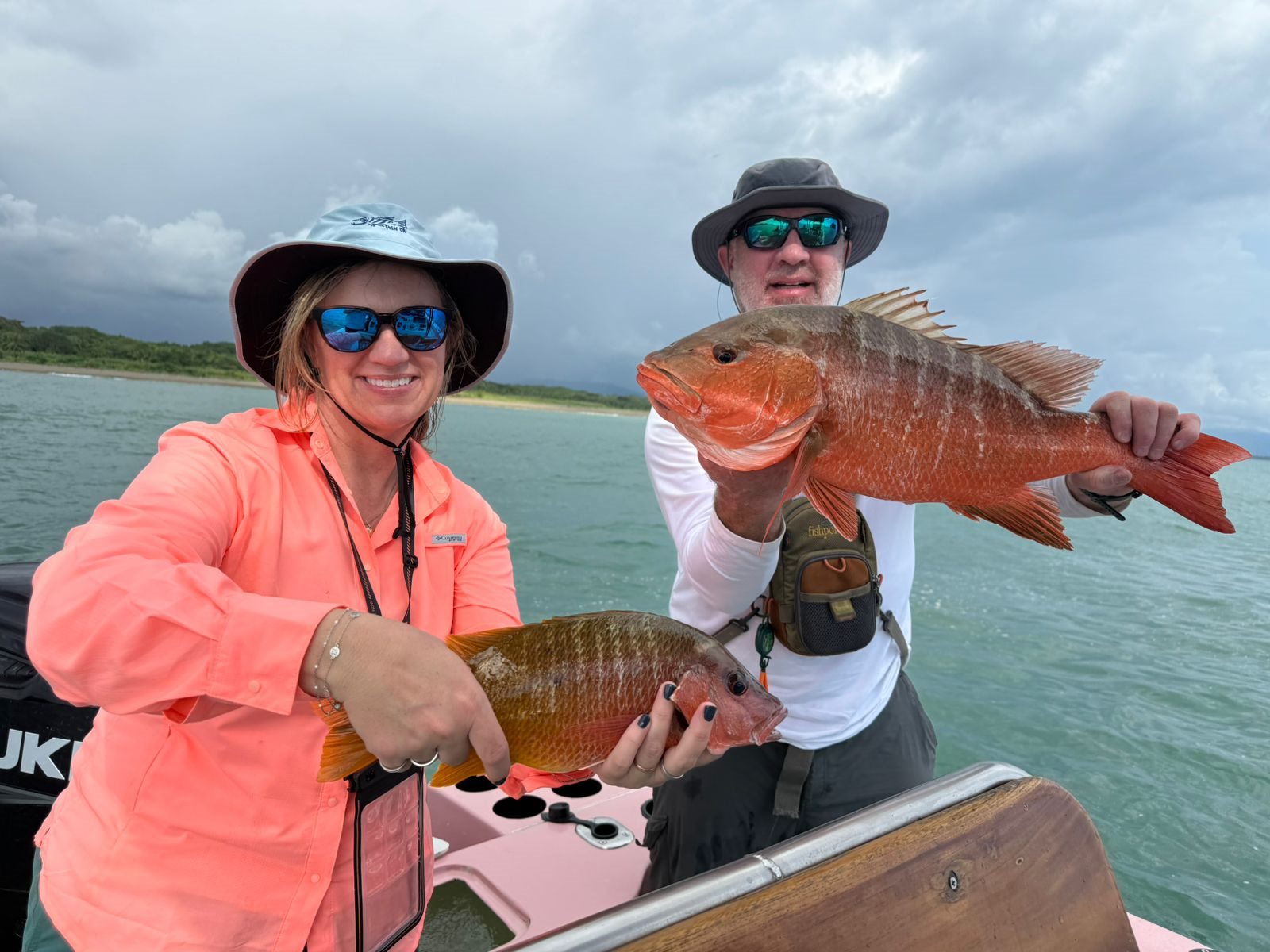 Woman and Captain Roy Zapata smiling with a red snapper