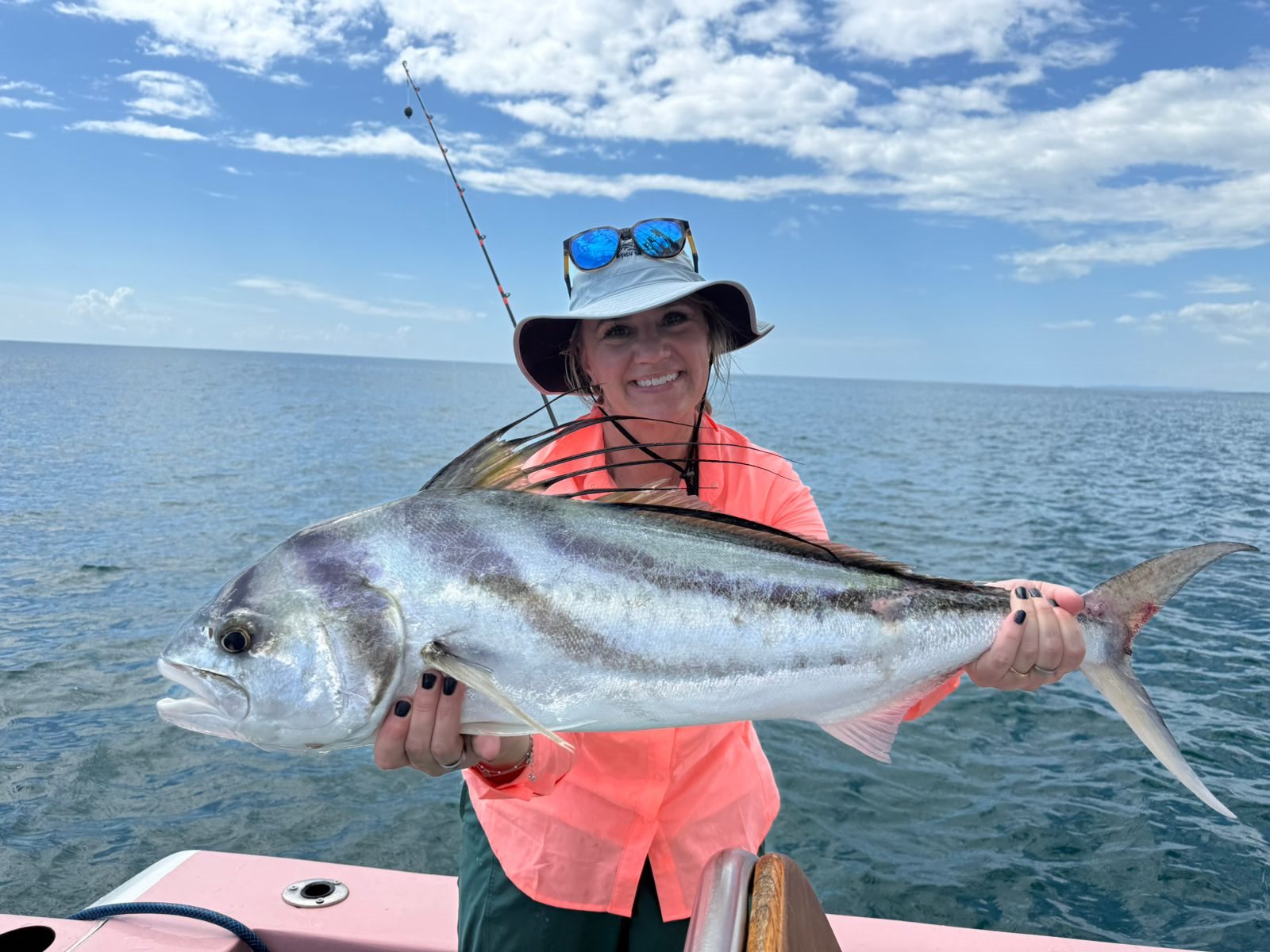 Woman holding a large roosterfish aboard Zapata Fishing