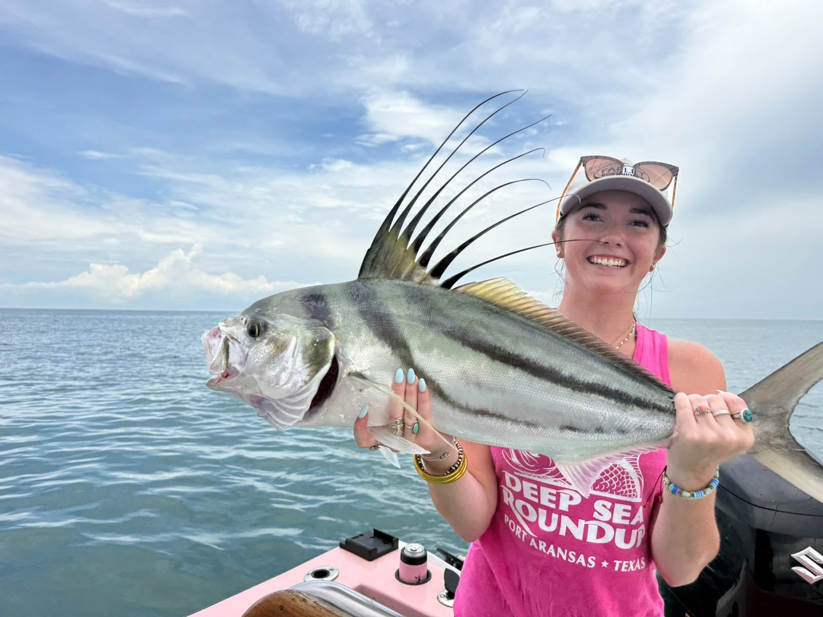 Smiling woman holding a roosterfish