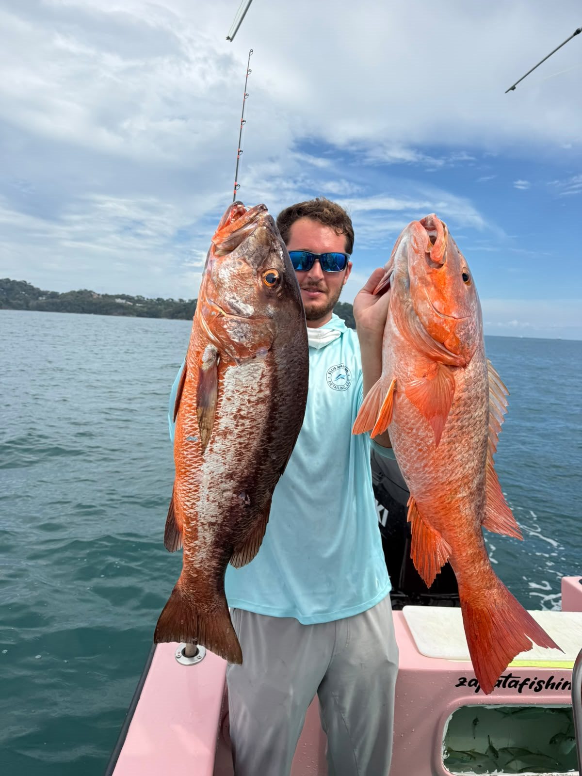 Two large red fish displayed aboard the charter