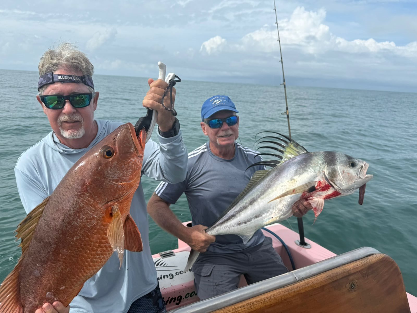 Two anglers with different large fish from one trip