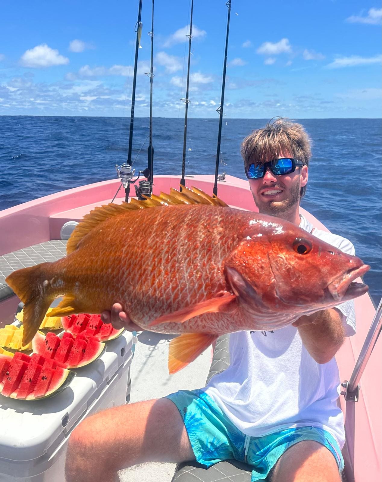 Young adult angler holding a large red snapper aboard Zapata Fishing
